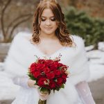 Bride holding red rose bouquet in winter Central Park wedding